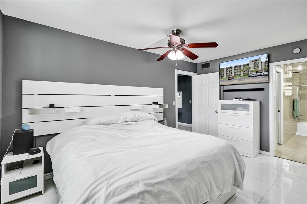 9235 Lagoon Place, Unit 207 Davie, FL 33324 - Photo 19 of 59 a bedroom with a bed and a chandelier