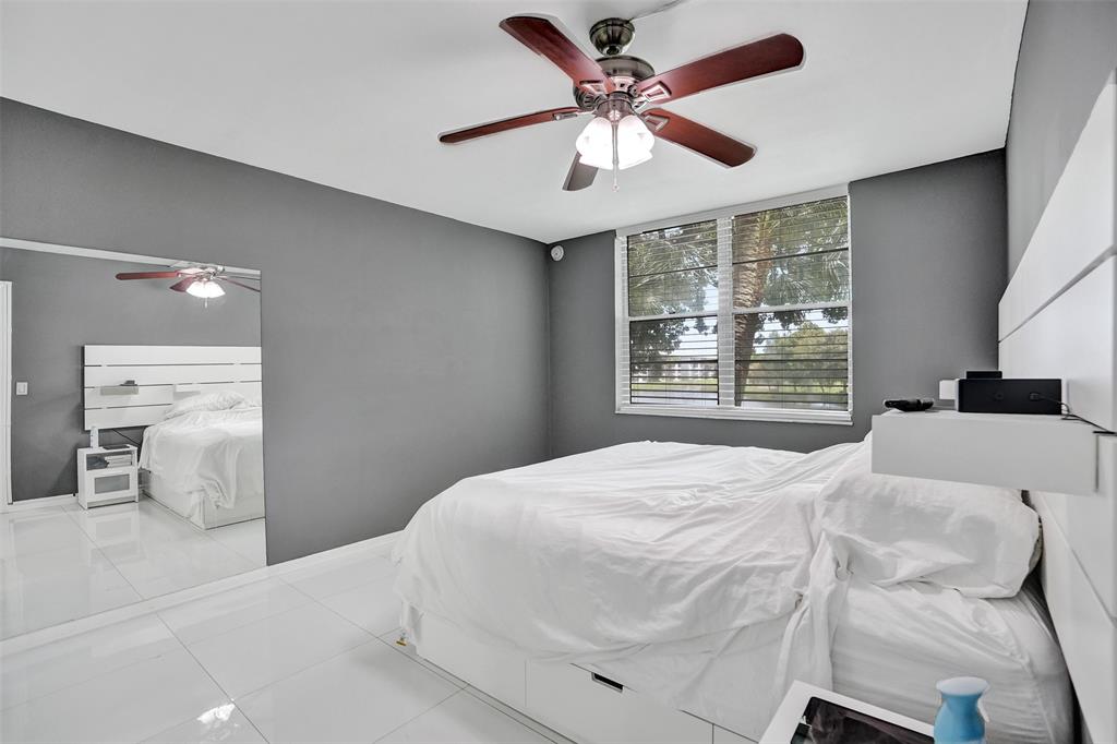 9235 Lagoon Place, Unit 207 Davie, FL 33324 - Photo 20 of 59 a bedroom with a large bed and a large window