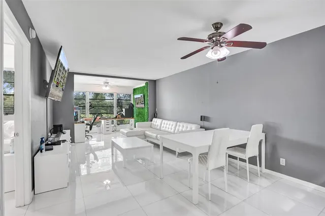a dining room with chandelier fan and wooden floor