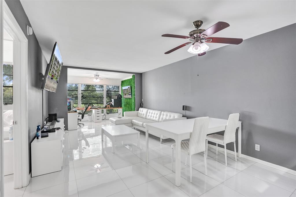 9235 Lagoon Place, Unit 207 Davie, FL 33324 - Photo 2 of 59 a dining room with chandelier fan and wooden floor