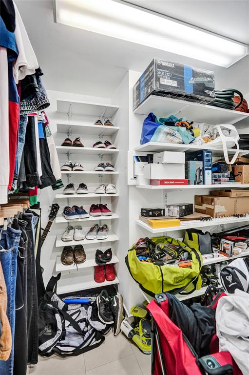 9235 Lagoon Place, Unit 207 Davie, FL 33324 - Photo 25 of 59 a view of walk in closet with clothes and shoes