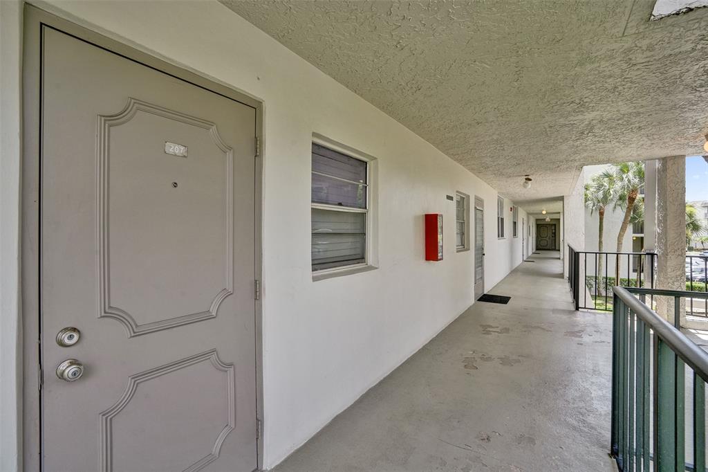 9235 Lagoon Place, Unit 207 Davie, FL 33324 - Photo 29 of 59 a view of a hallway with workspace and entryway door