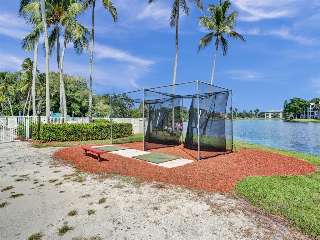 9235 Lagoon Place, Unit 207 Davie, FL 33324 - Photo 38 of 59 a backyard of a house with table and chairs under an umbrella