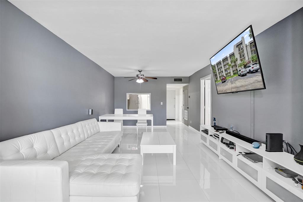9235 Lagoon Place, Unit 207 Davie, FL 33324 - Photo 10 of 59 a living room with furniture and a flat screen tv