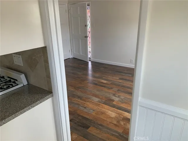 a view of a hallway with wooden floor and closet
