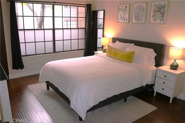 a bedroom with a bed and wooden floor