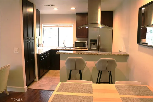 a kitchen with stainless steel appliances granite countertop a sink and a refrigerator