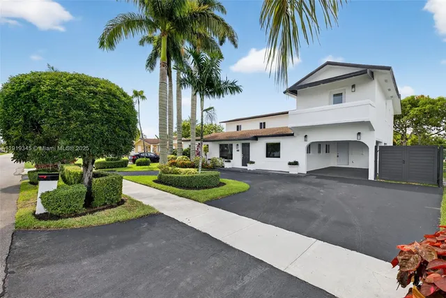 a front view of a house with a garden and trees