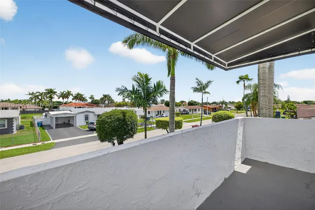 a view of a house with backyard and a tree