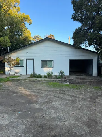 a view of a house with backyard and trees