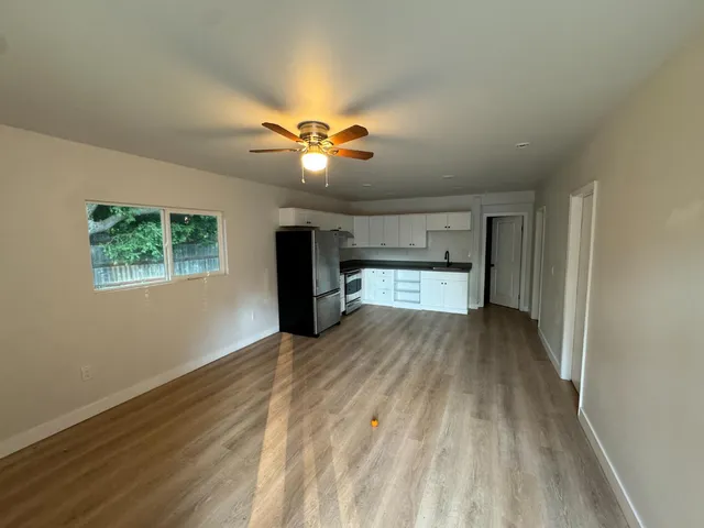 a view of an empty room with a kitchen