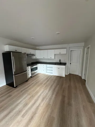 a kitchen with granite countertop a refrigerator and a sink