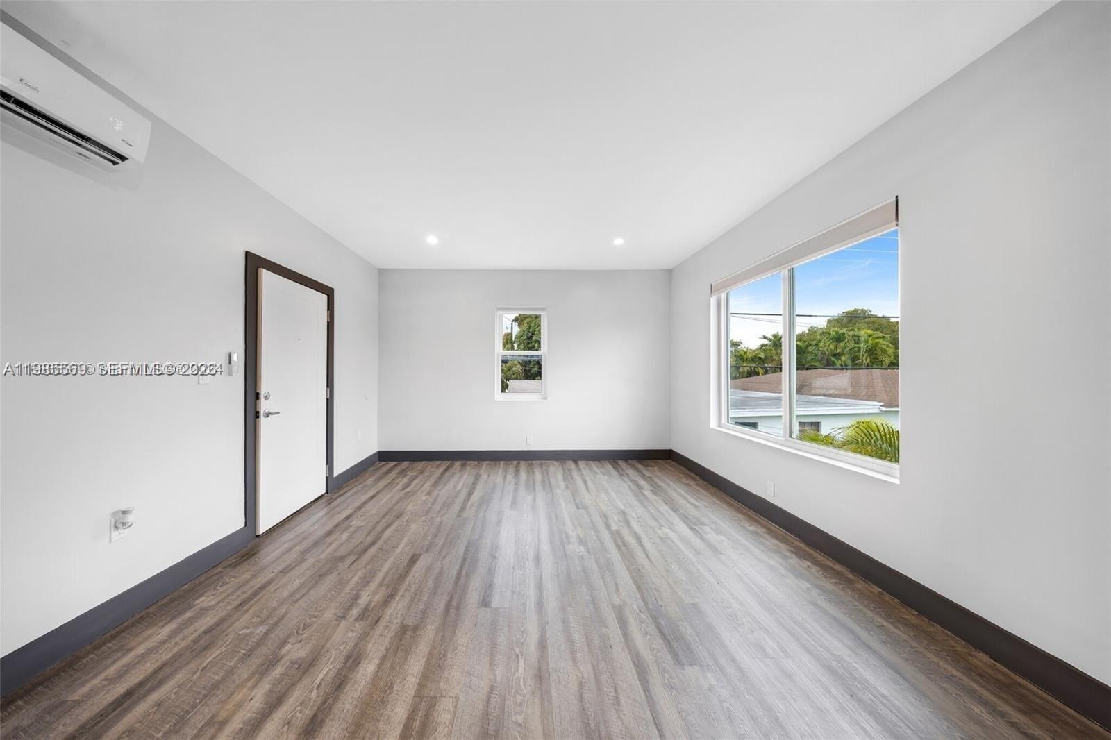 1020 Southwest 23rd Avenue, Unit 4 Miami, FL 33135 - Photo 5 of 17 an empty room with wooden floor and windows