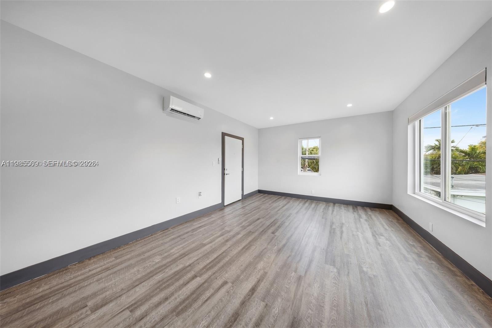 1020 Southwest 23rd Avenue, Unit 4 Miami, FL 33135 - Photo 8 of 17 an empty room with wooden floor and windows