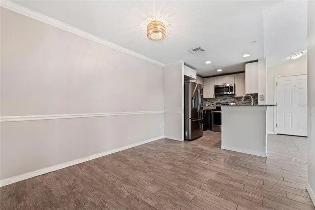 a kitchen with stainless steel appliances granite countertop a sink refrigerator and cabinets