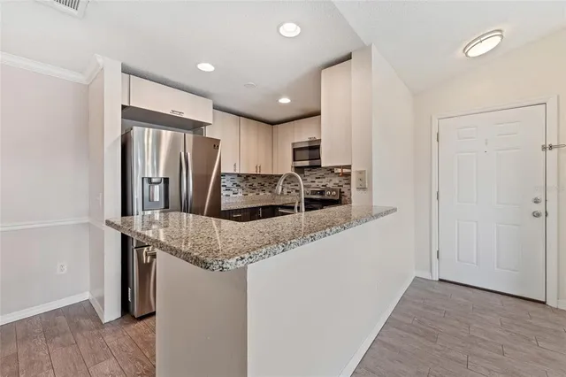 a kitchen with granite countertop a sink and stainless steel appliances