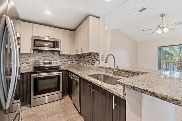 a kitchen with granite countertop a stove sink and cabinets