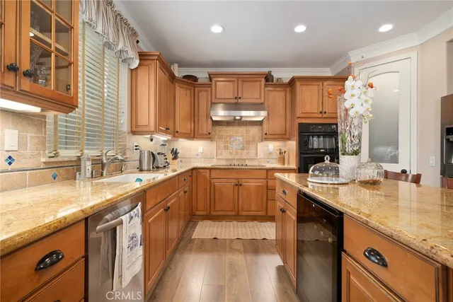 a kitchen with stainless steel appliances granite countertop a sink stove and cabinets