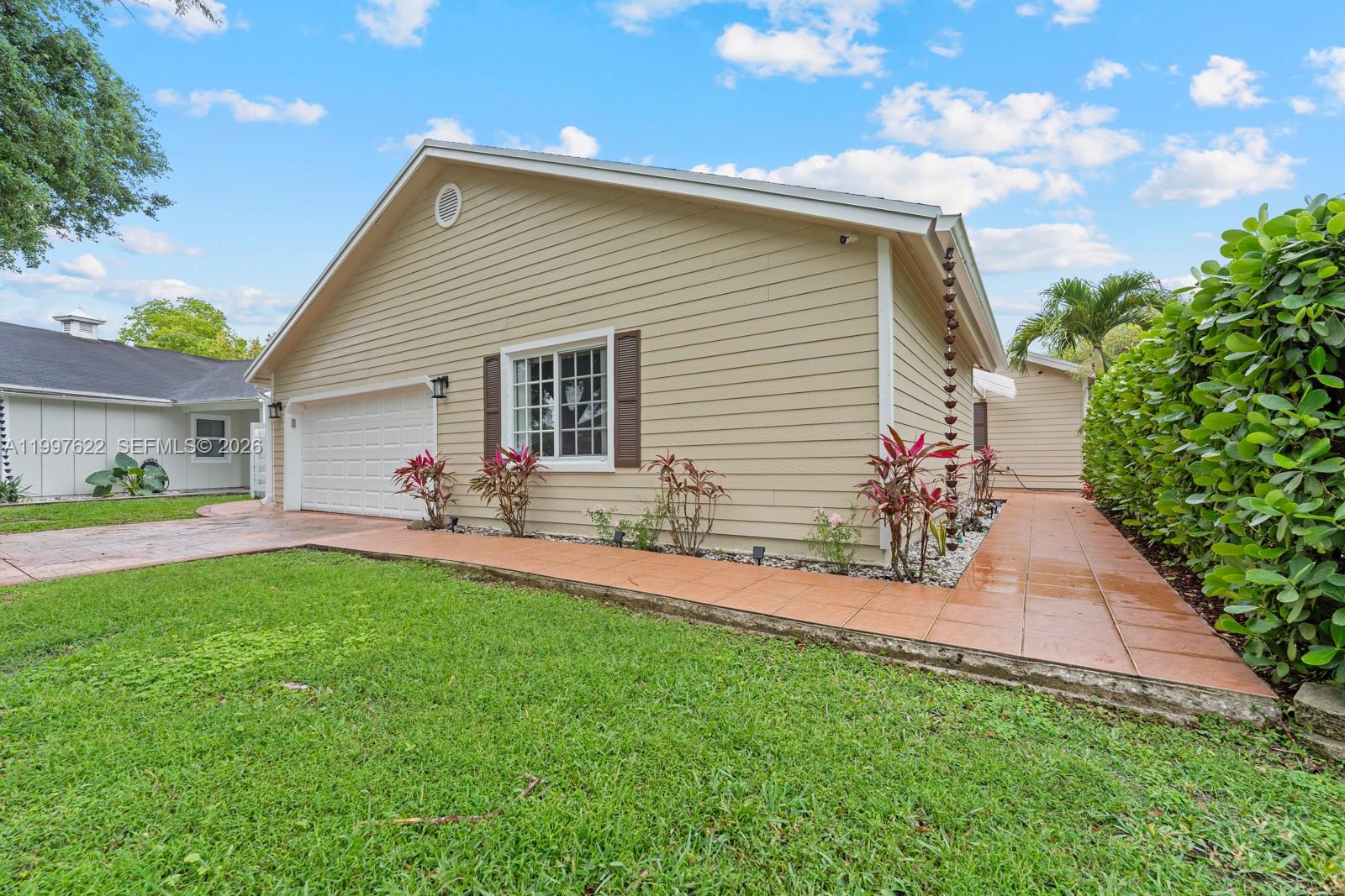 14912 Southwest 143rd Court, Unit 14912 Miami, FL 33186 - Photo 1 of 35 a front view of house with yard and outdoor seating