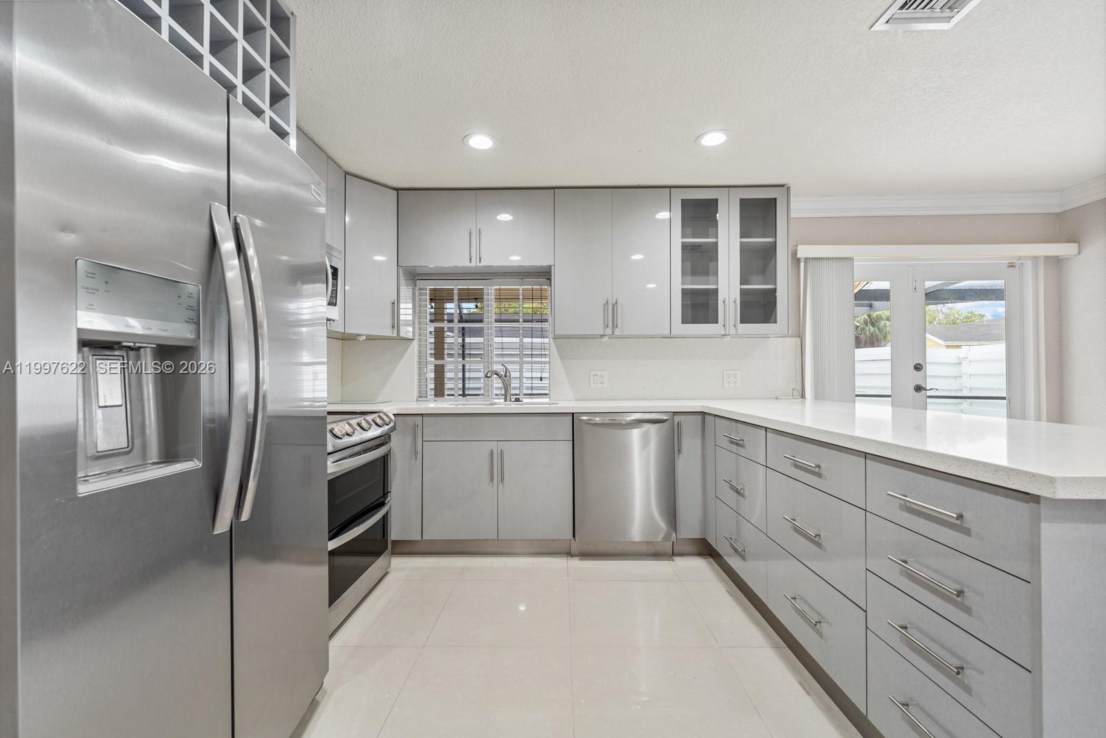 14912 Southwest 143rd Court, Unit 14912 Miami, FL 33186 - Photo 13 of 35 a kitchen with granite countertop white cabinets and stainless steel appliances