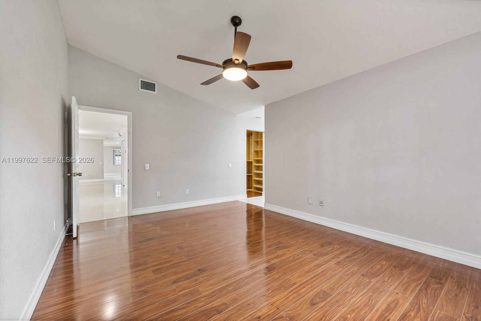 14912 Southwest 143rd Court, Unit 14912 Miami, FL 33186 - Photo 18 of 35 wooden floor in an empty room with a window