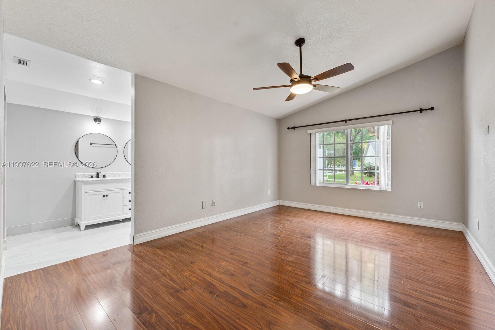 14912 Southwest 143rd Court, Unit 14912 Miami, FL 33186 - Photo 19 of 35 wooden floor in an empty room with a window