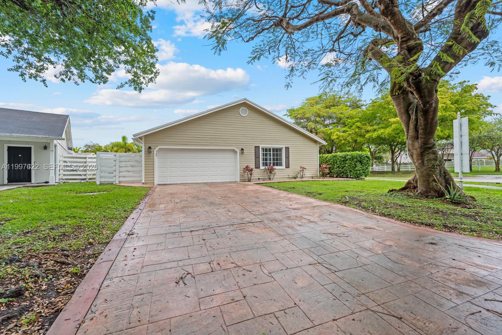 14912 Southwest 143rd Court, Unit 14912 Miami, FL 33186 - Photo 2 of 35 a front view of a house with a yard and trees