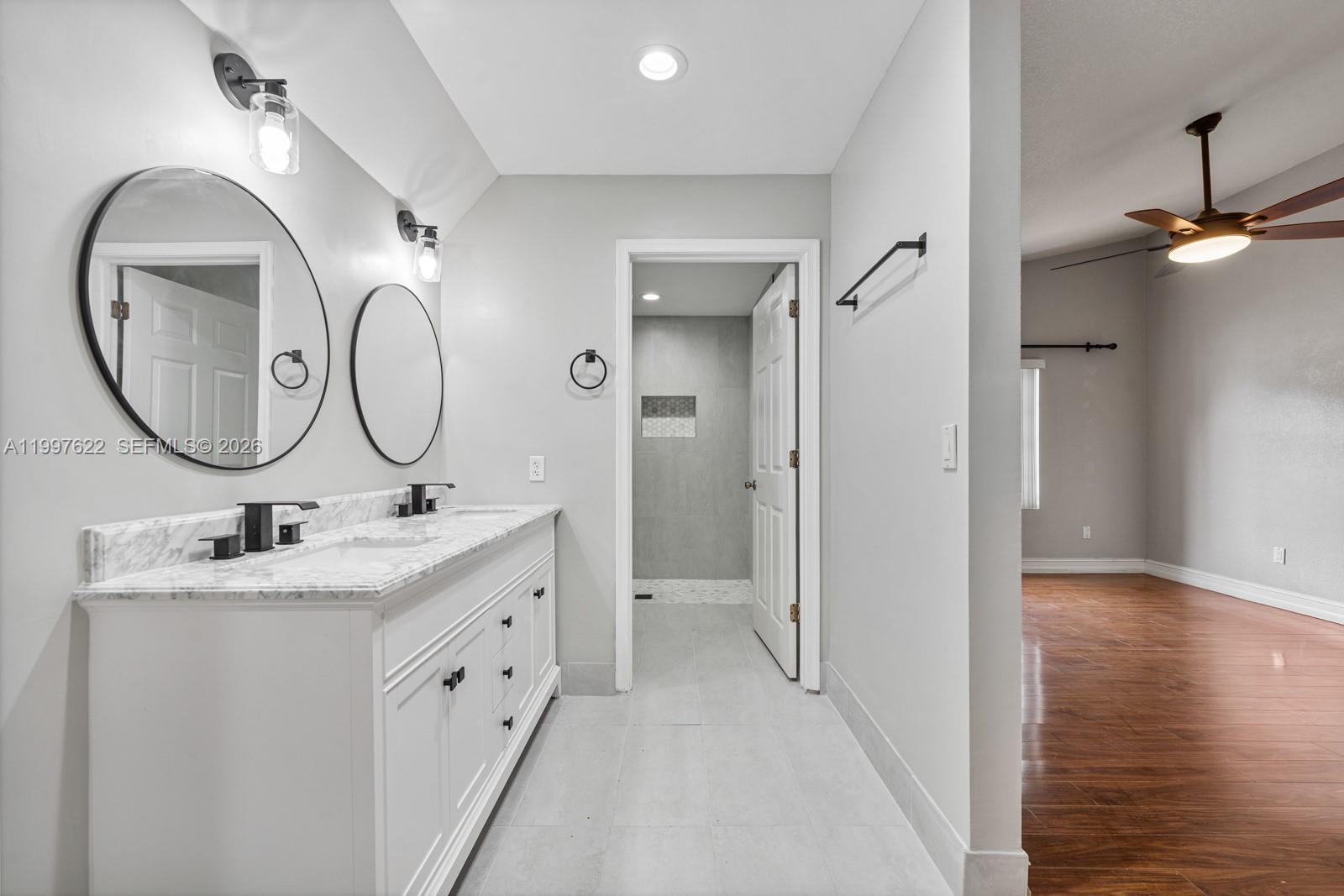 14912 Southwest 143rd Court, Unit 14912 Miami, FL 33186 - Photo 21 of 35 a bathroom with a double vanity sink mirror and shower