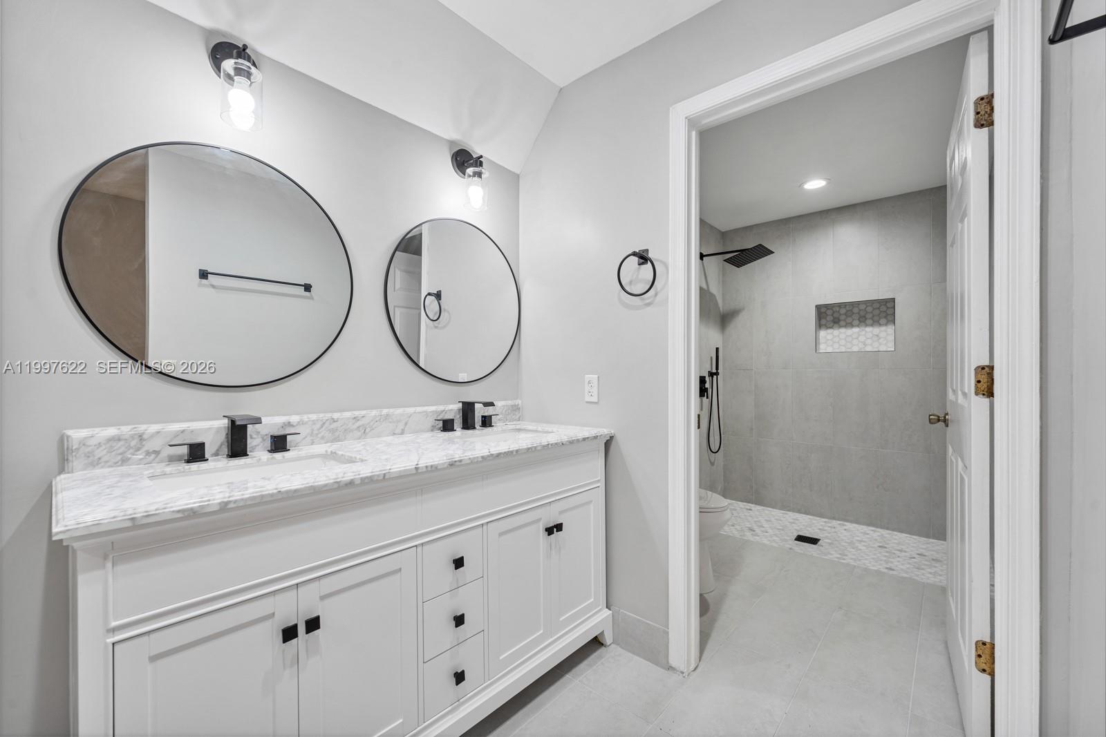 14912 Southwest 143rd Court, Unit 14912 Miami, FL 33186 - Photo 22 of 35 a bathroom with a double vanity sink mirror and shower