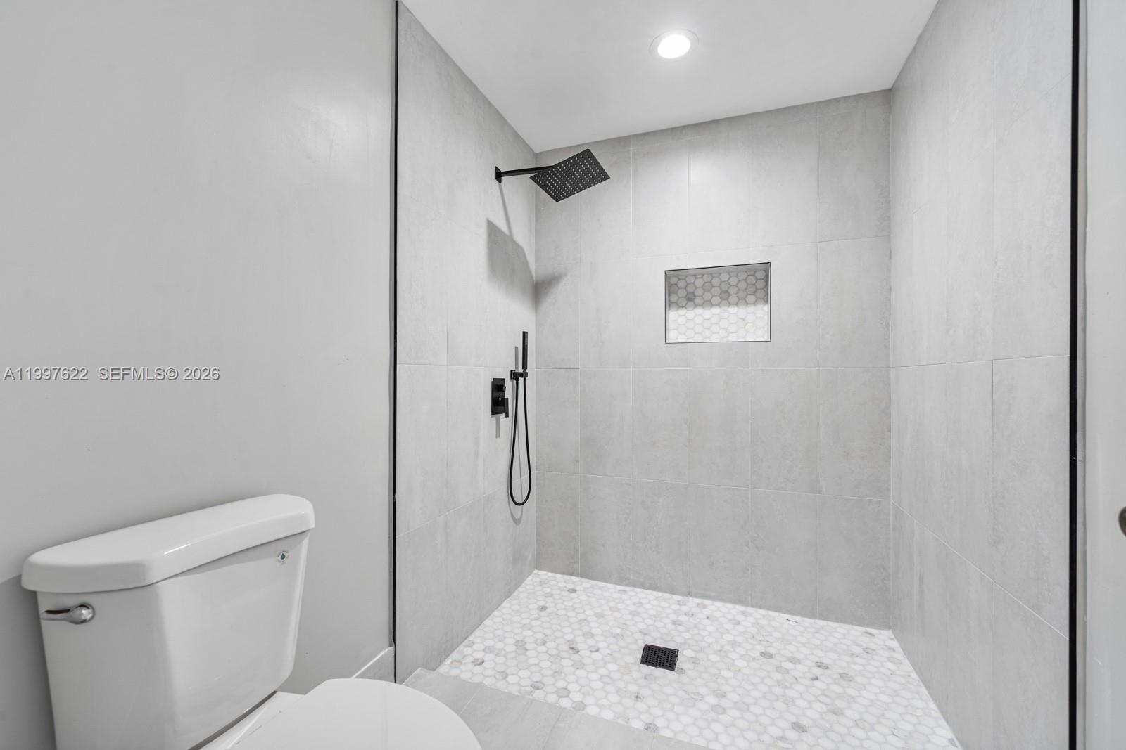 14912 Southwest 143rd Court, Unit 14912 Miami, FL 33186 - Photo 23 of 35 a bathroom with a toilet and a shower