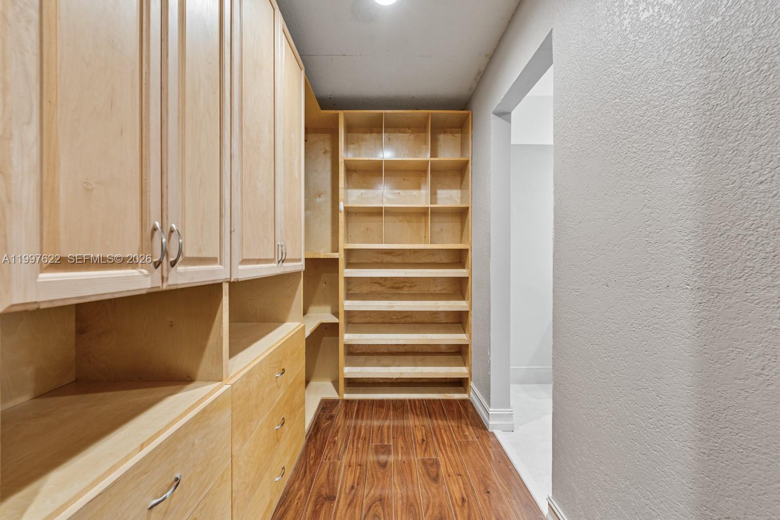 14912 Southwest 143rd Court, Unit 14912 Miami, FL 33186 - Photo 25 of 35 a view of walk in closet with empty racks