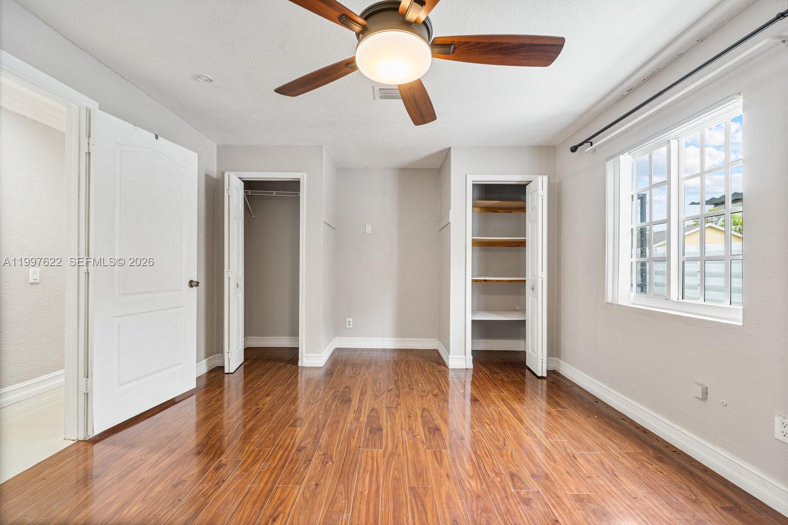 14912 Southwest 143rd Court, Unit 14912 Miami, FL 33186 - Photo 27 of 35 wooden floor in an empty room with a window
