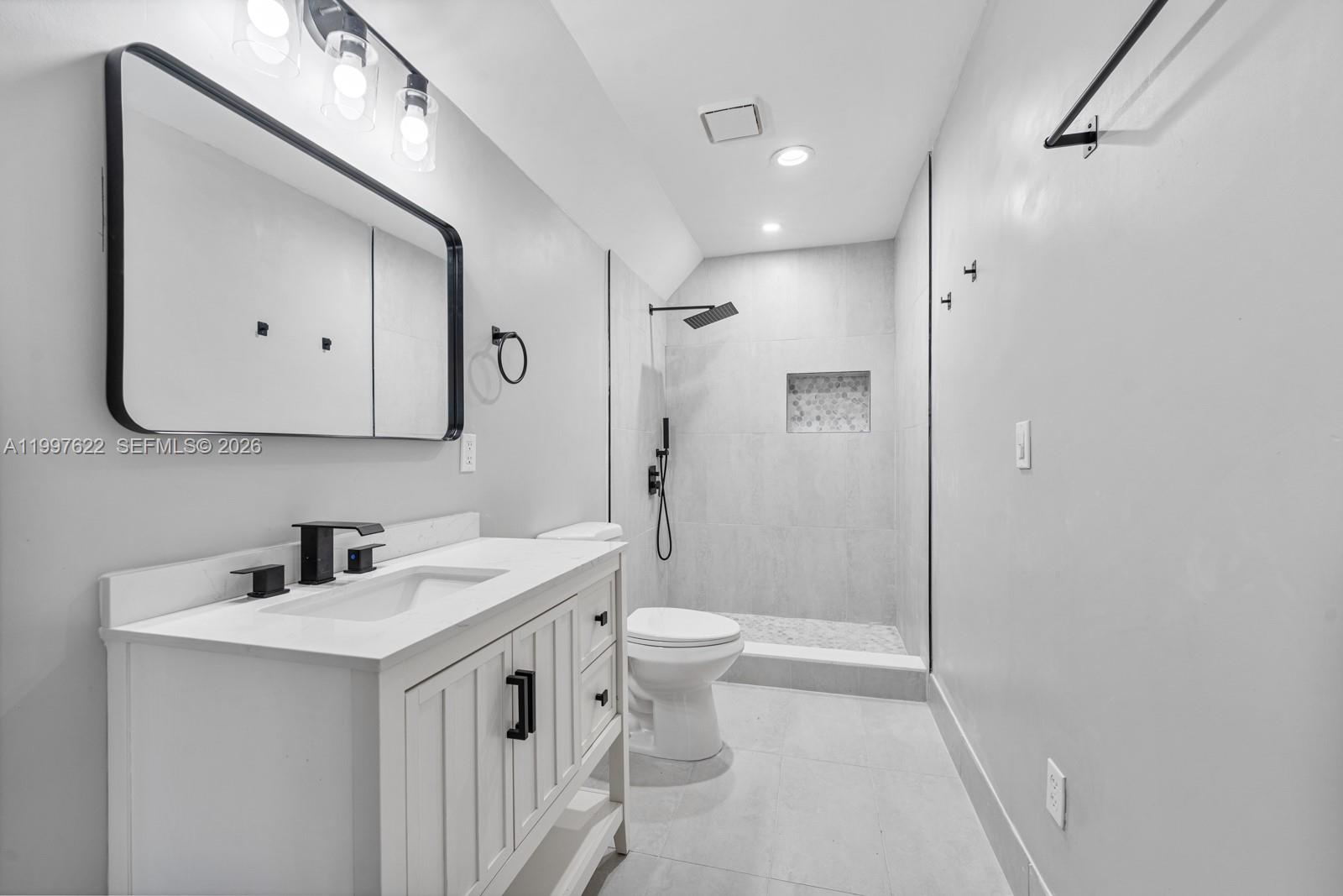 14912 Southwest 143rd Court, Unit 14912 Miami, FL 33186 - Photo 30 of 35 a bathroom with a double vanity sink mirror and toilet