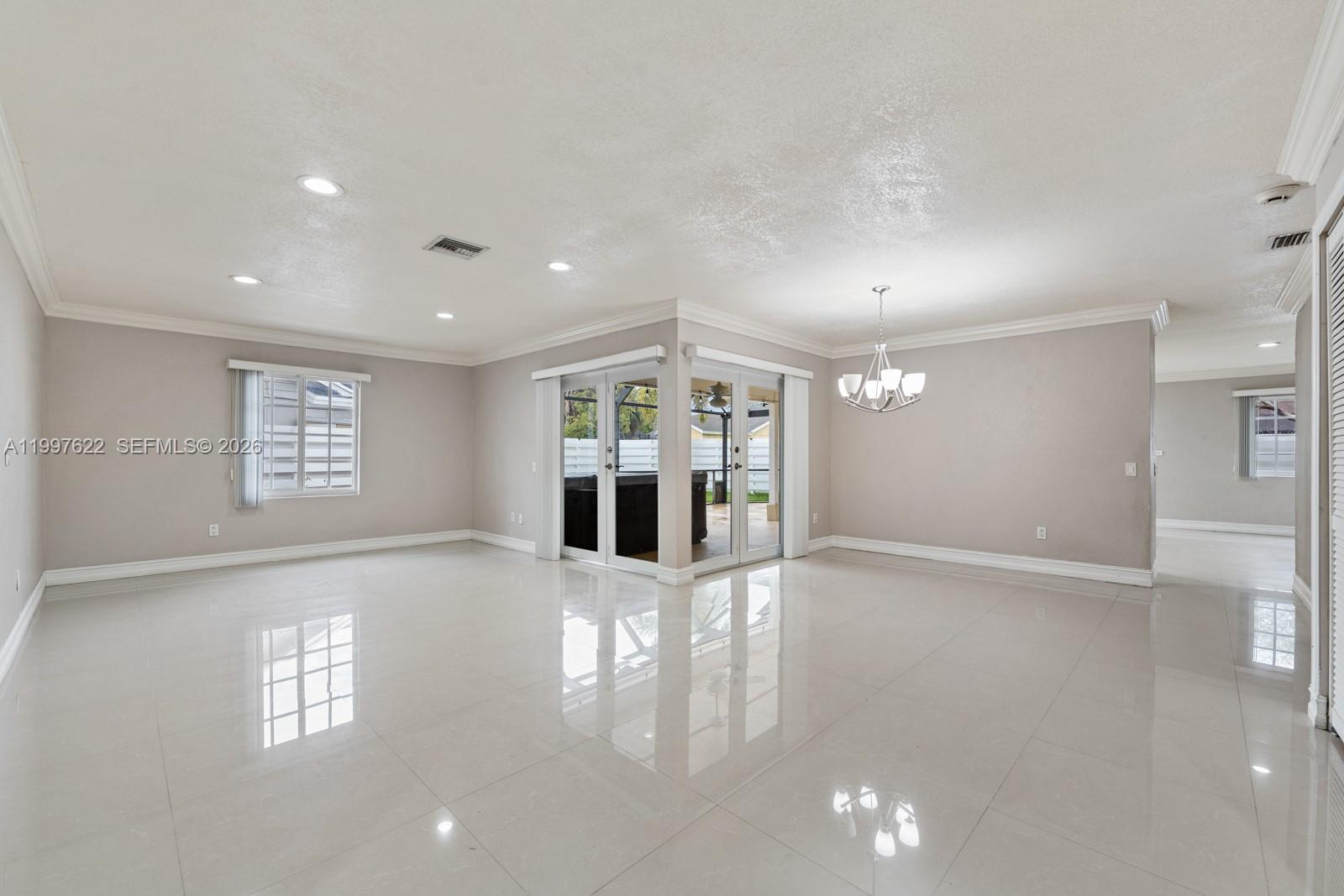 14912 Southwest 143rd Court, Unit 14912 Miami, FL 33186 - Photo 8 of 35 a view of a big room with windows and chandelier