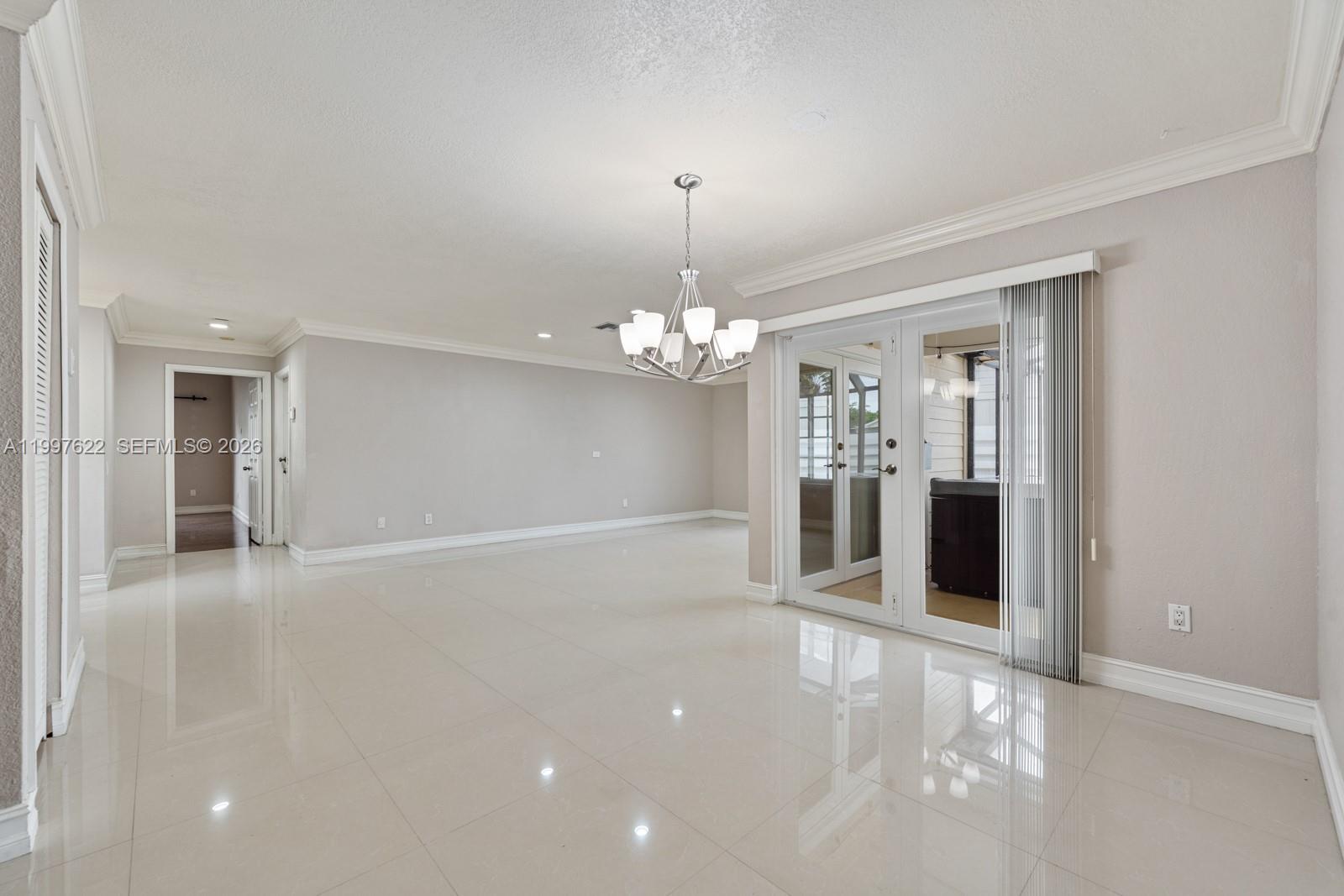 14912 Southwest 143rd Court, Unit 14912 Miami, FL 33186 - Photo 9 of 35 a view of a livingroom with a chandelier fan and windows
