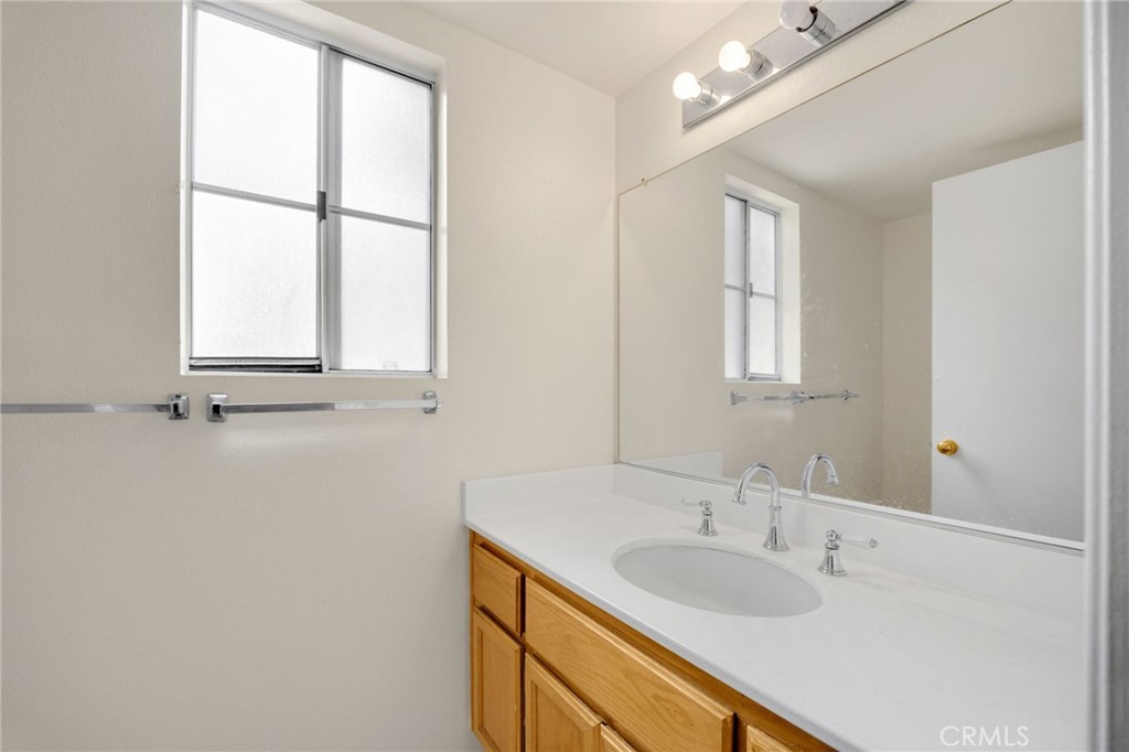 3631 Snowdrift Drive Riverside, CA 92503 - Photo 24 of 36 a bathroom with a granite countertop sink a mirror and a window