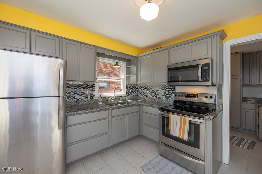 21475 Eaton Road Cleveland, OH 44126 - Photo 13 of 31 Kitchen featuring gray cabinetry, backsplash, stainless steel appliances, and sink