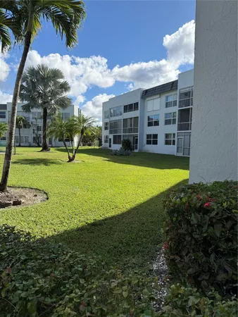 a view of a large pool with lawn chairs and a yard