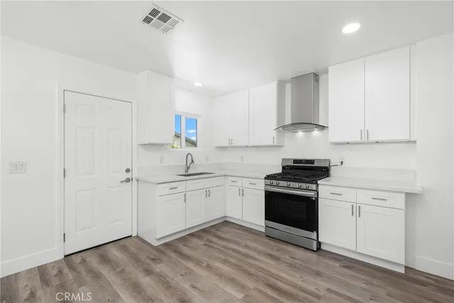 a kitchen with stainless steel appliances granite countertop a stove a sink and a refrigerator