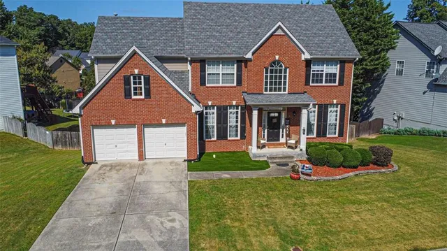 a front view of a house with a yard and garage