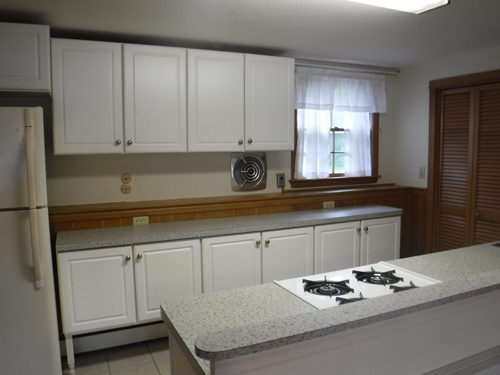 53 Ryder Road Weymouth, MA 02190 - Photo 26 of 29 a kitchen with granite countertop white cabinets white stove a sink and dishwasher