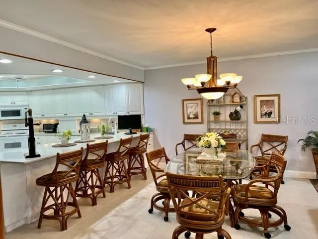 a view of a dining room and livingroom with furniture wooden floor a chandelier