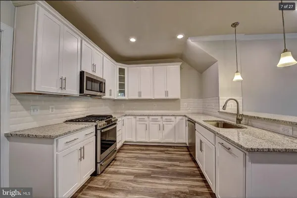 a kitchen with granite countertop a sink and cabinets