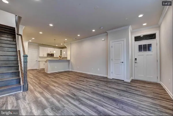 a view of kitchen with kitchen island granite countertop cabinets and refrigerator