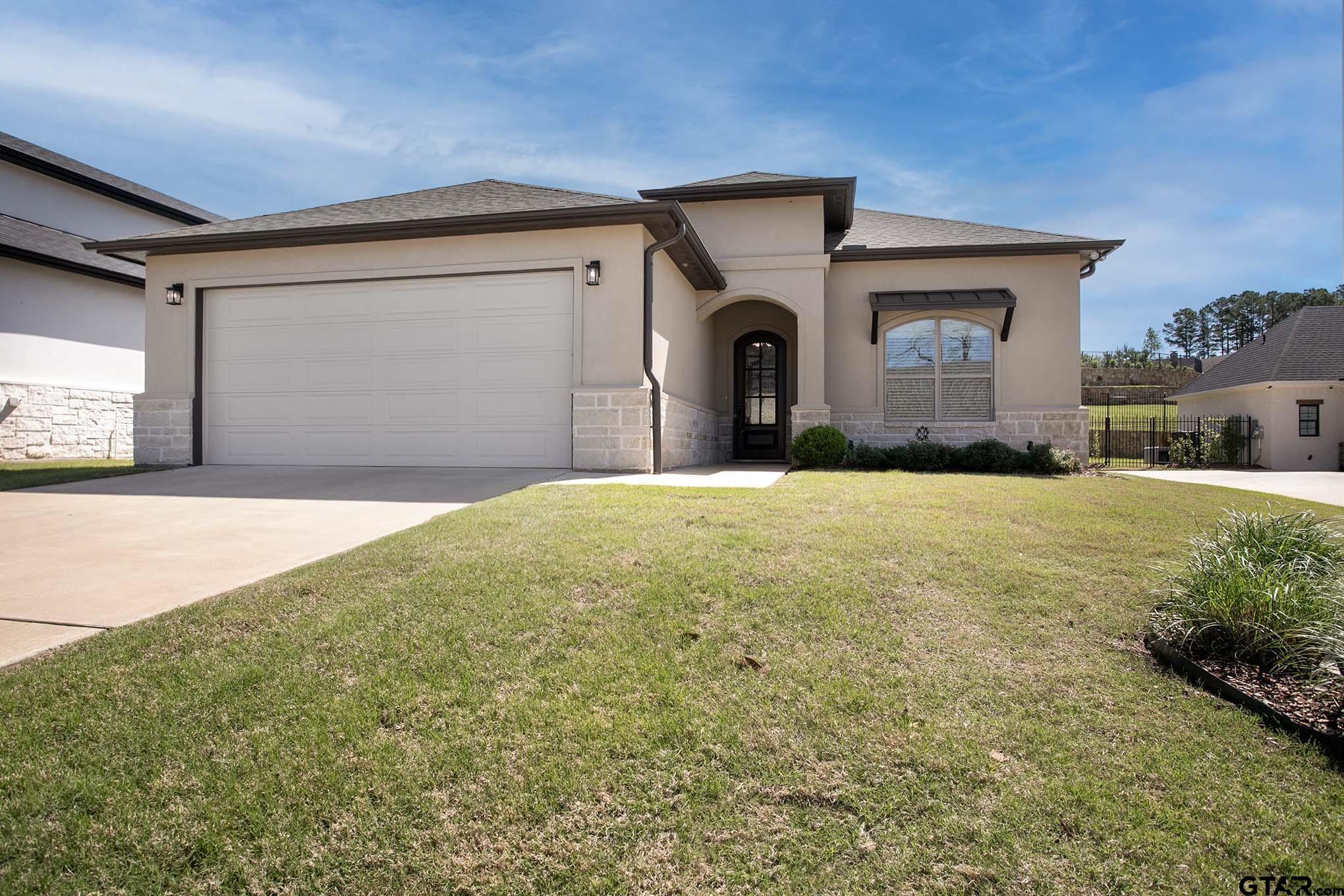 a view of a house with a yard and garage