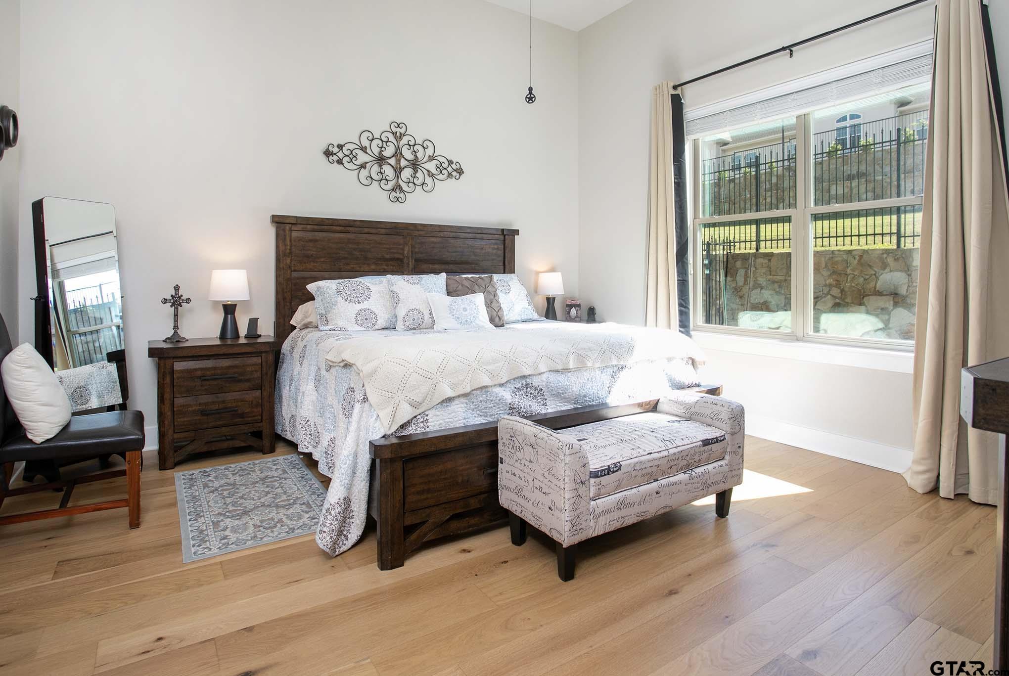 7434 Waterview Square Tyler, TX 75703 - Photo 13 of 33 a bedroom with a bed wooden floor and a large window