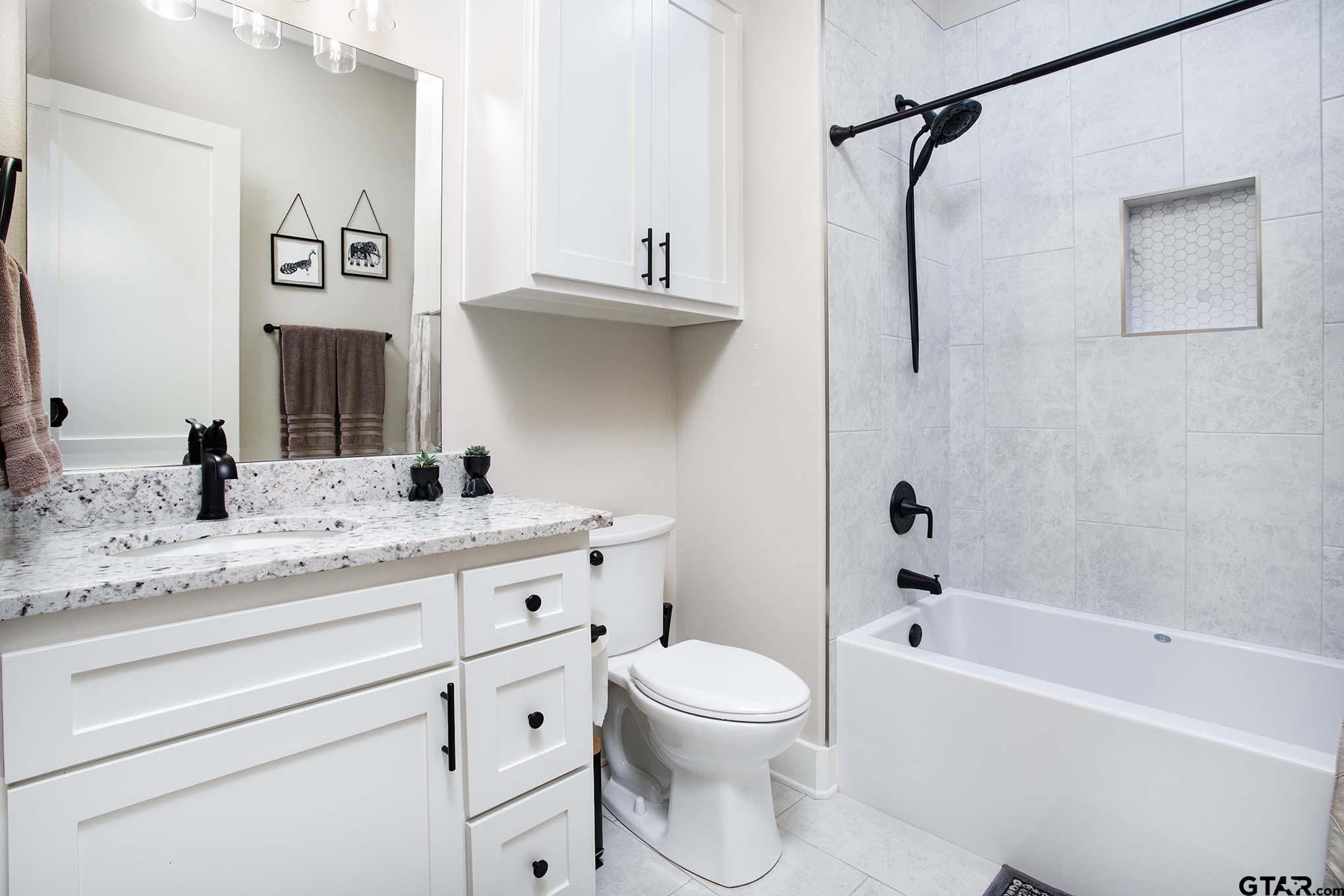 7434 Waterview Square Tyler, TX 75703 - Photo 25 of 33 a bathroom with a granite countertop sink a toilet and a bathtub
