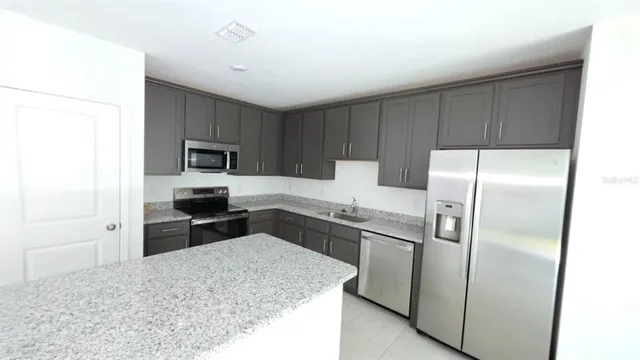 a kitchen with a refrigerator sink and microwave