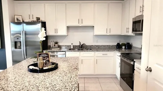 a kitchen with stainless steel appliances granite countertop a sink a stove and a refrigerator