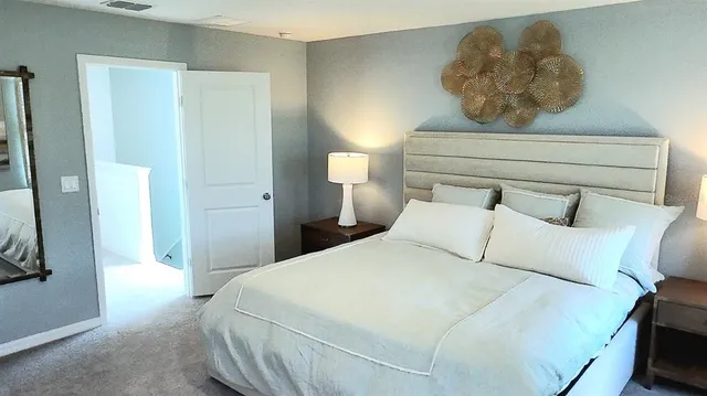 a bedroom with a bed and a painting on the wall